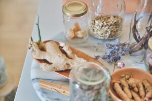 a picture of ginger, lavender, galangal and oatstraw in glass containers on a marble table 