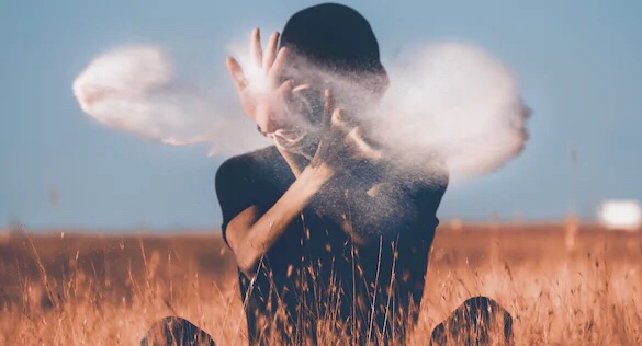 Picture of someone in a field with pollen swirling around 